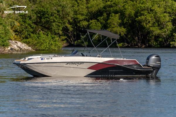 Starcraft SVX 231 OB DH 2023 Starcraft SVX 231 OB DH boat on a calm river with lush greenery.