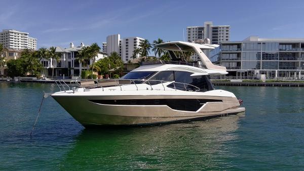 Galeon 500 Fly 2023 Galeon 500 Fly yacht on calm water, with modern buildings in the background.