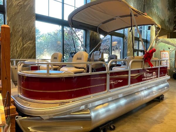 Sun Tracker Bass Buggy 18 DLX 2025 Sun Tracker Bass Buggy 18 DLX pontoon boat with canopy, displayed indoors.