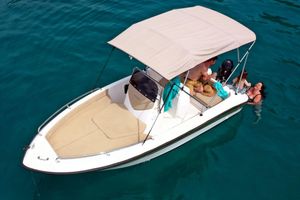 Orizzonti CHIOS Small Chios 2023 boat with canopy on clear blue water, people enjoying leisure time.