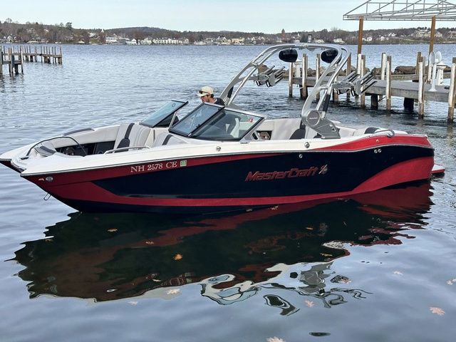 MasterCraft X22 2021 MasterCraft X22 boat on a calm lake near a dock.