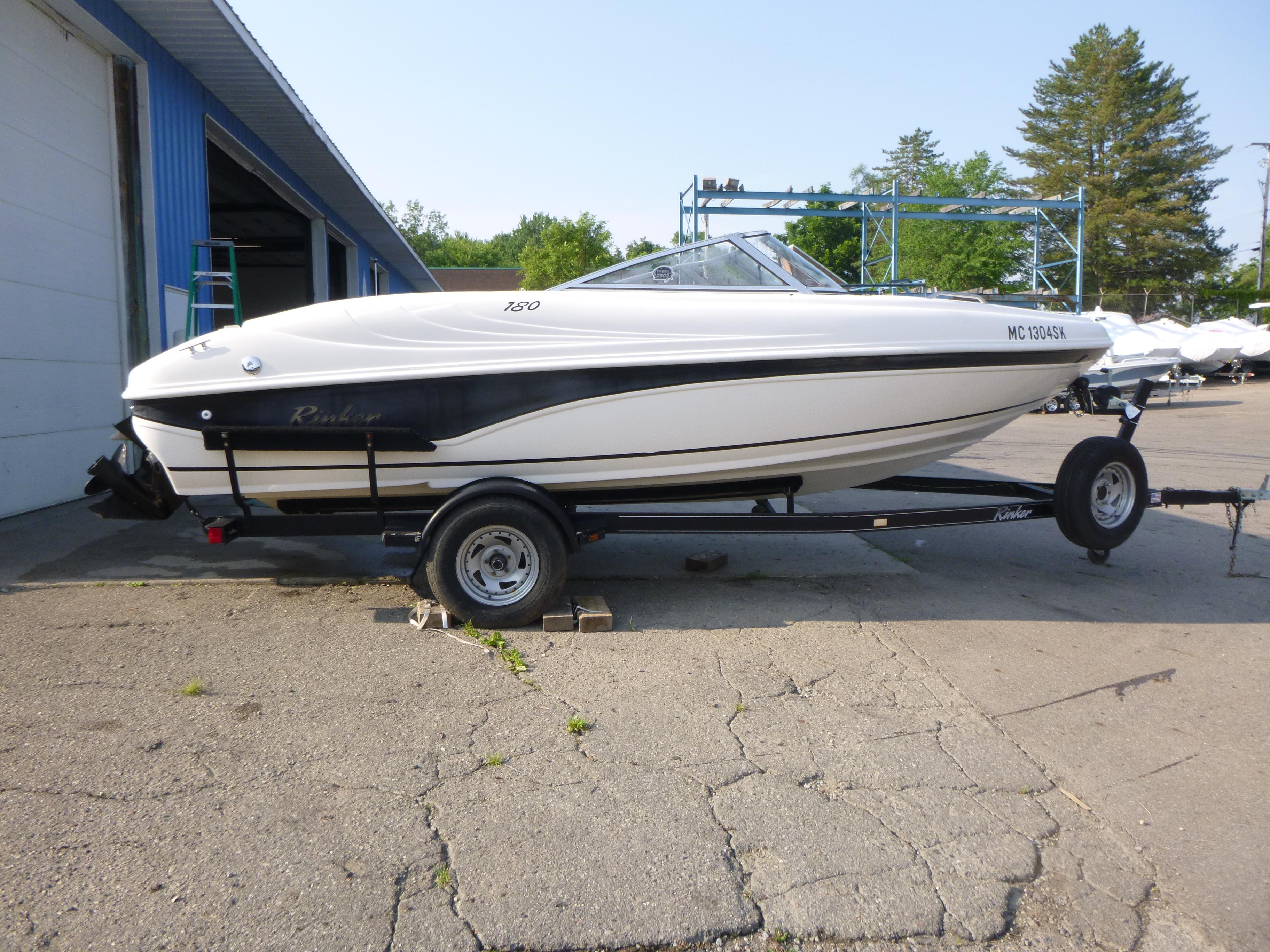 Rinker 180 BR 2003 Rinker 180 BR boat on trailer, parked outside a blue building.