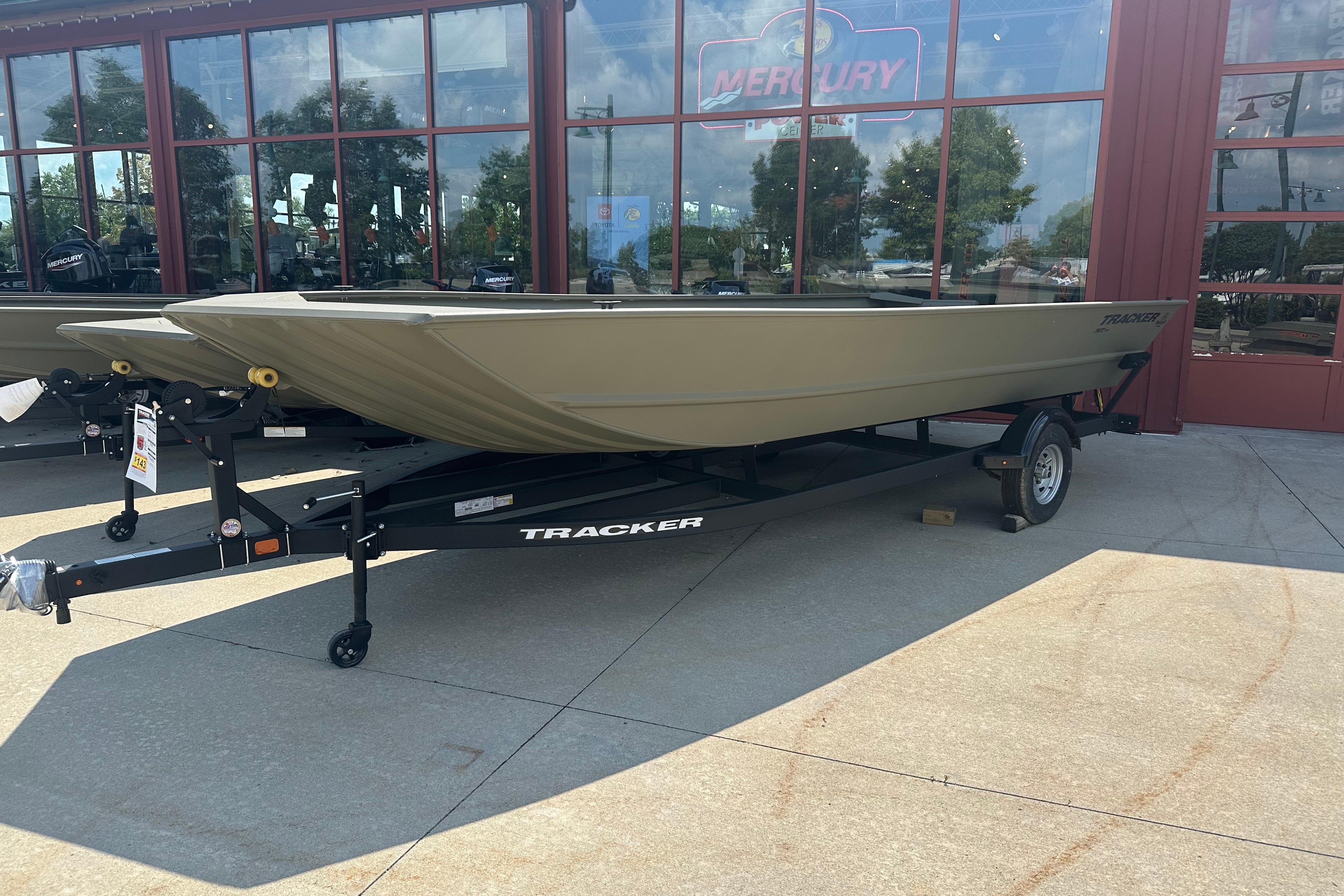 Tracker GRIZZLY 2072 Utility 2026 Tracker GRIZZLY 2072 Utility boat on trailer outside dealership.