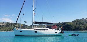 Elan 444 Sailboat Elan 444, 2011 model, anchored in clear blue water near a lush coastline.