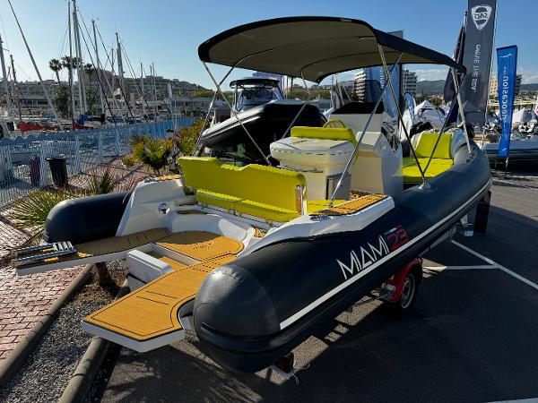 Blue RIB Miami 23 2024 Blue RIB Miami 23 boat with yellow seating, docked at a marina.