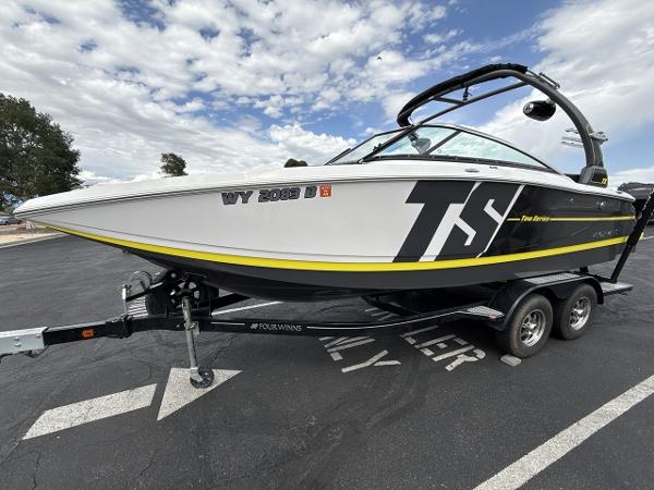 Four Winns TS242 2017 Four Winns TS242 boat on trailer, parked outdoors under cloudy sky.