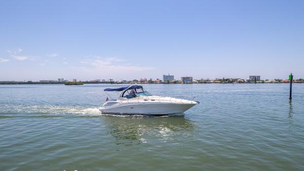 Sea Ray 340 Sundancer 2005 Sea Ray 340 Sundancer cruising on calm waters with cityscape in the background.