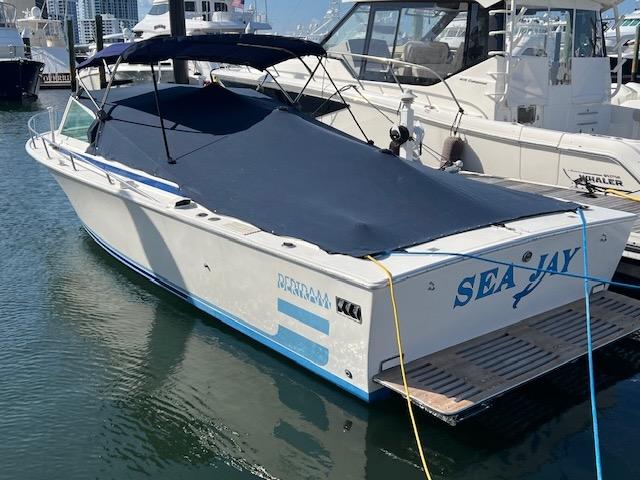 Bertram Express Moppie 1984 Bertram Express Moppie boat named "Sea Jay" docked at a marina.
