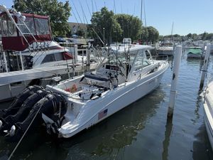 Donzi 38 ZSF 2007 Donzi 38 ZSF boat docked in a marina with fishing rods and outboard motors.