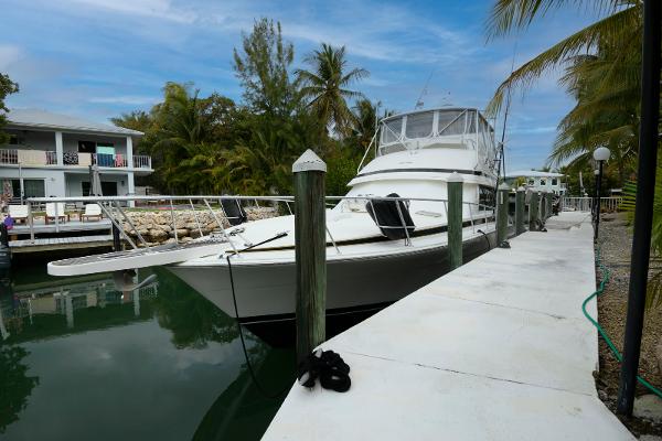 Bertram 50 Convertible 1989 Bertram 50 Convertible yacht docked by a tropical waterfront.
