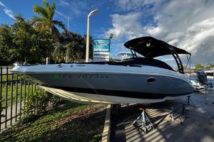 NauticStar 243 DC 2021 NauticStar 243DC boat on display, sunny day, palm trees, and blue sky background.