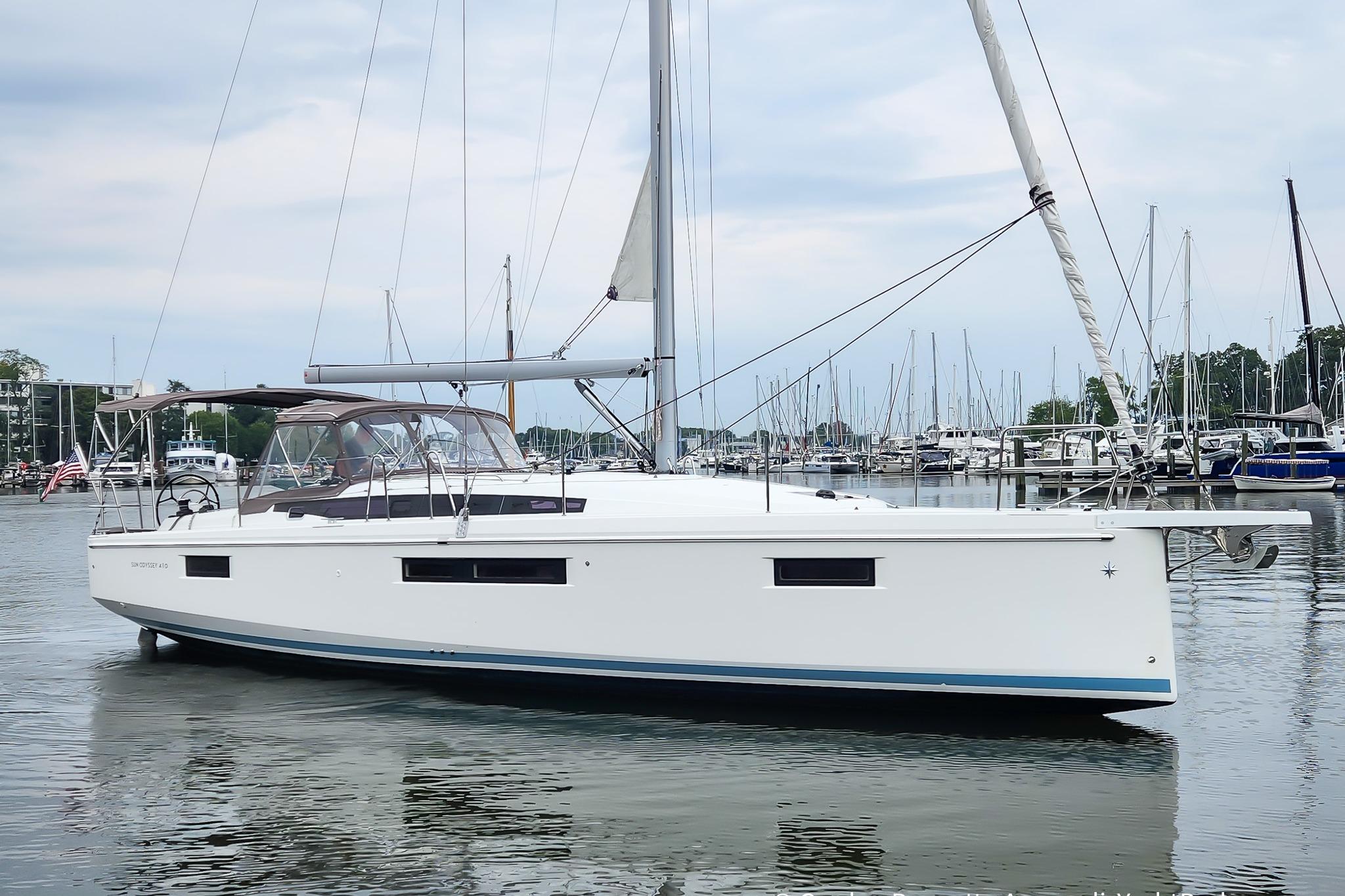 Jeanneau Sun Odyssey 410 2022 Jeanneau Sun Odyssey 410 sailboat docked in a marina, calm waters, overcast sky.