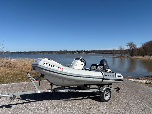 Highfield Sport 360 2023 Highfield Sport 360 boat on trailer by a lake under clear blue sky.