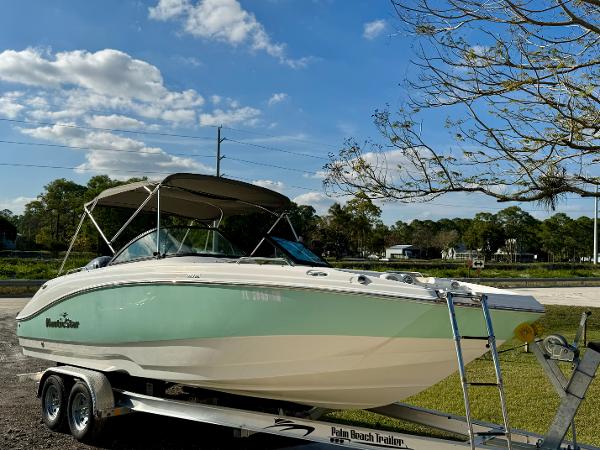 NauticStar 223 DC 2023 NauticStar 223 DC boat on trailer, parked outdoors under a blue sky.