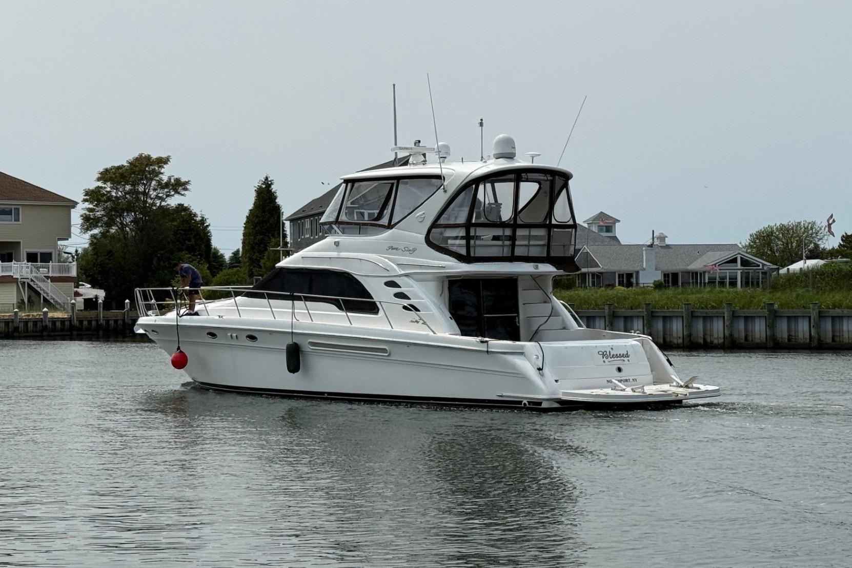 Sea Ray 560 Sedan Bridge 2001 Sea Ray 560 Sedan Bridge yacht cruising near waterfront homes.