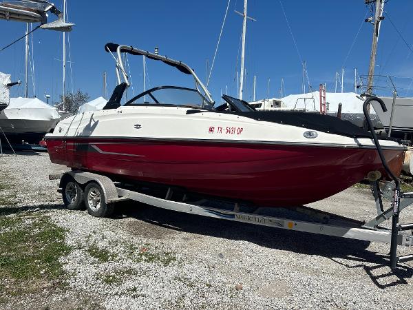 Bayliner 215 Deck Boat 2016 Bayliner 215 Deck Boat on trailer, red and white, parked outdoors.