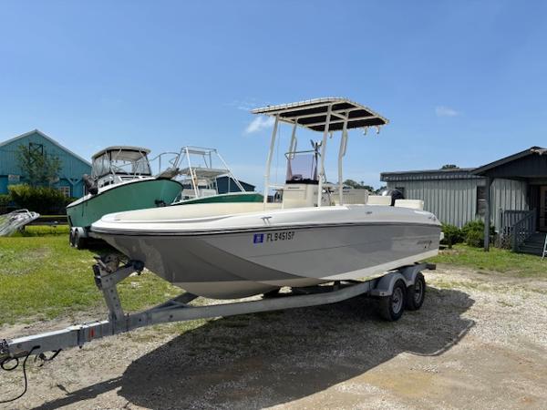Bayliner F-21 2019 Bayliner F-21 boat on trailer, parked outdoors under clear blue sky.
