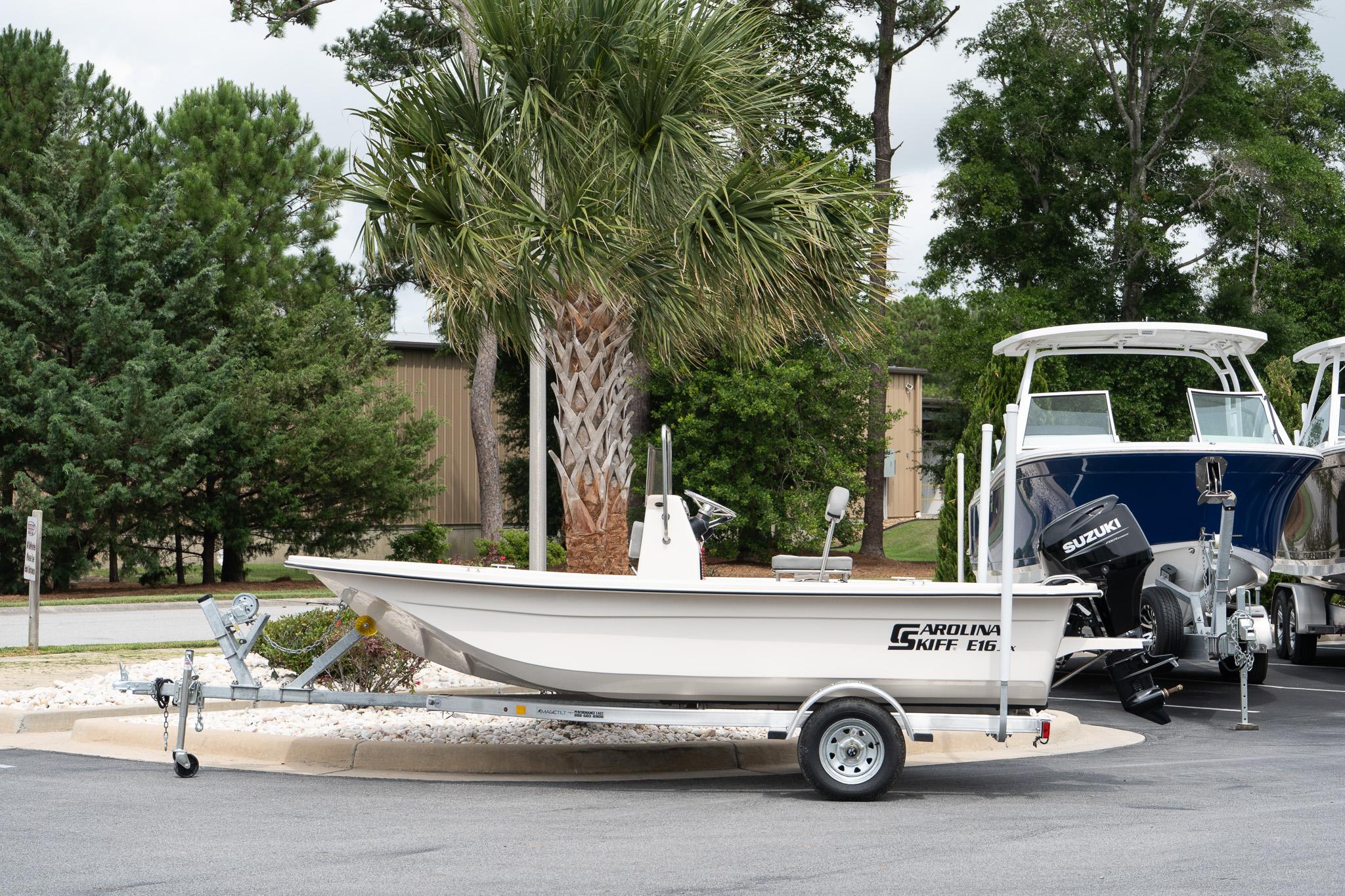 Carolina Skiff E16 JVX CC 2025 Carolina Skiff E16 JVX CC boat on trailer, parked outdoors with trees in background.