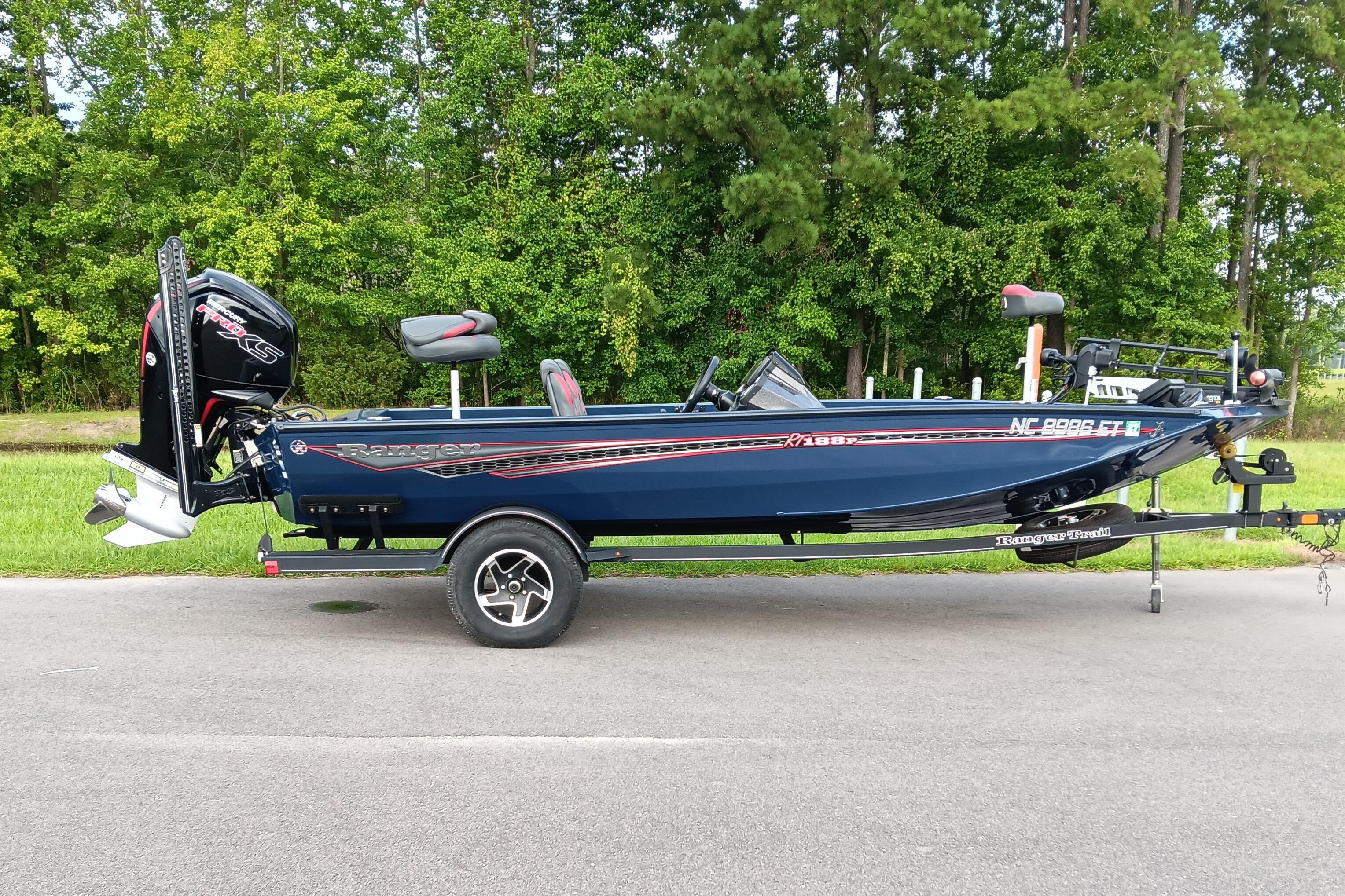 Ranger RT188P 2021 Ranger RT188P boat on trailer, parked on road with green trees in background.