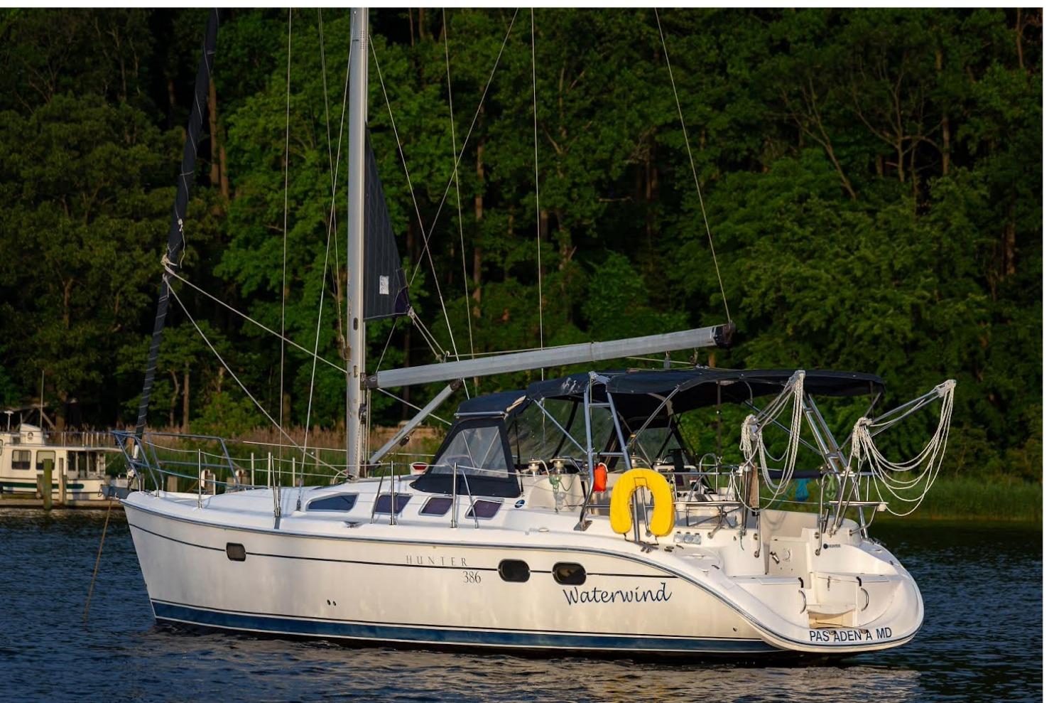 Hunter 386 Sailboat "Waterwind," Hunter 386, 2003 model, anchored near lush green trees.