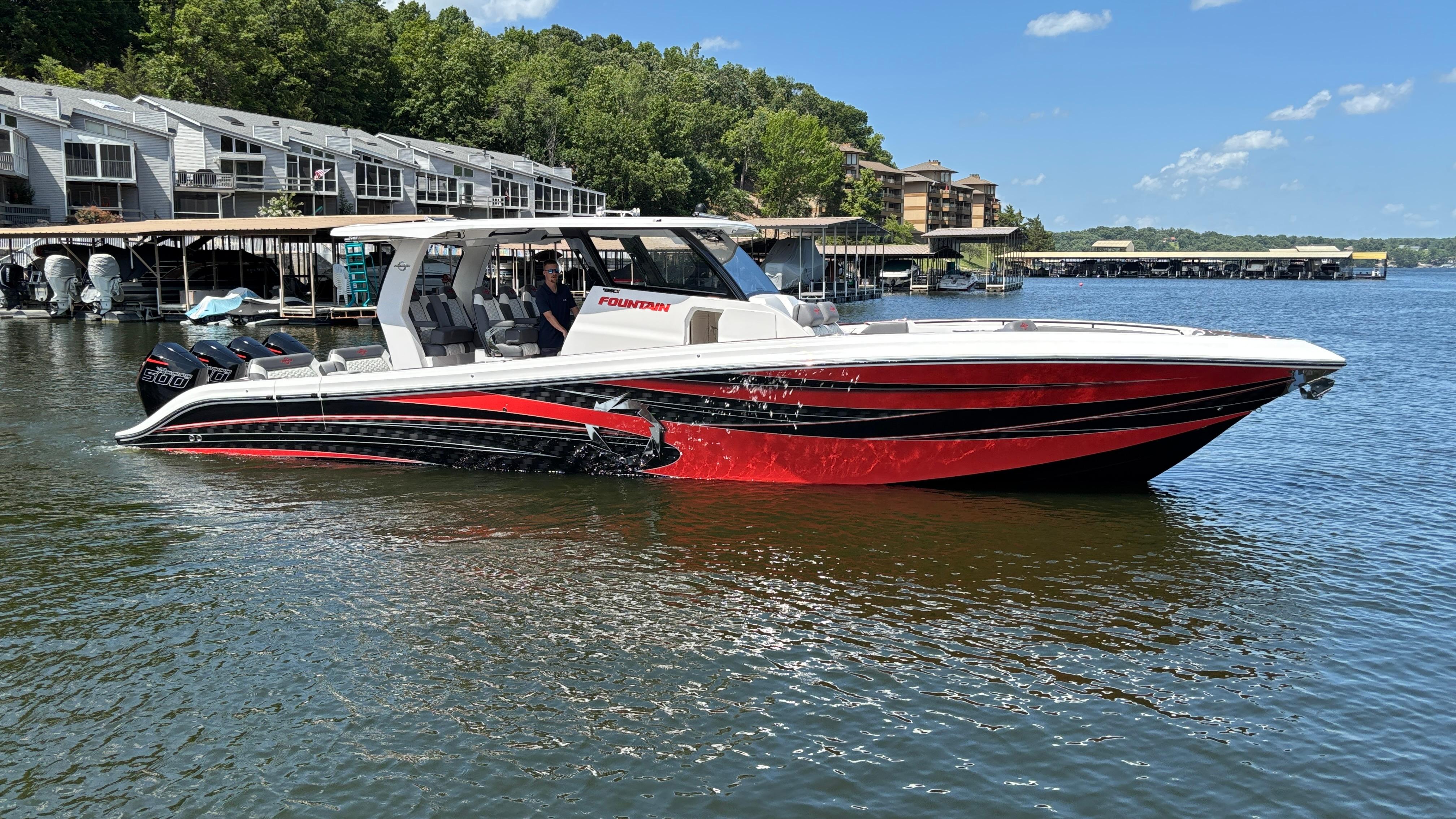 Fountain 43 SCX 2024 Fountain 43 SCX boat on a lake, featuring sleek red and black design.