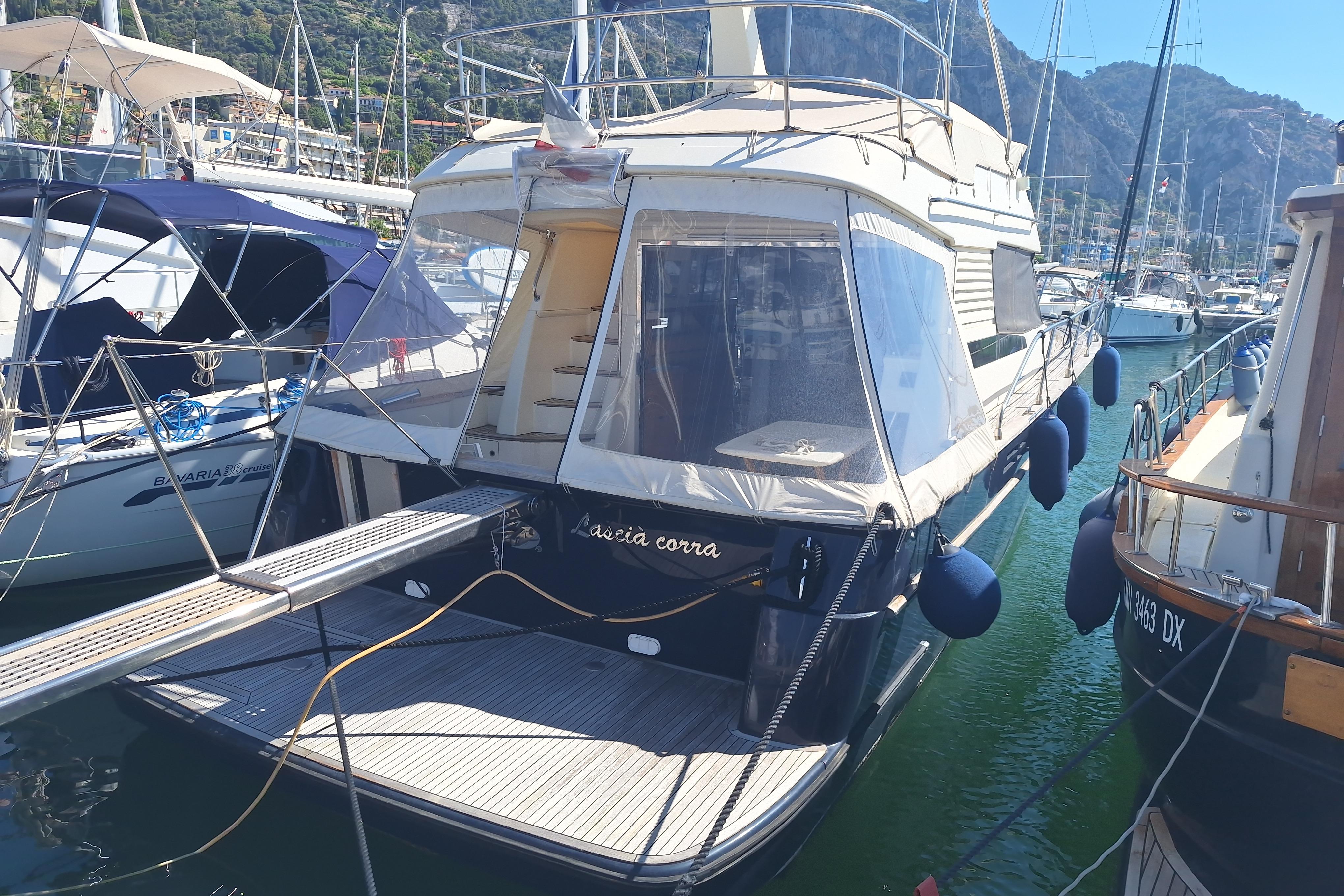 ACM Dynasty 43 ACM Dynasty 43 yacht, 2000 model, docked in a marina with scenic mountain backdrop.