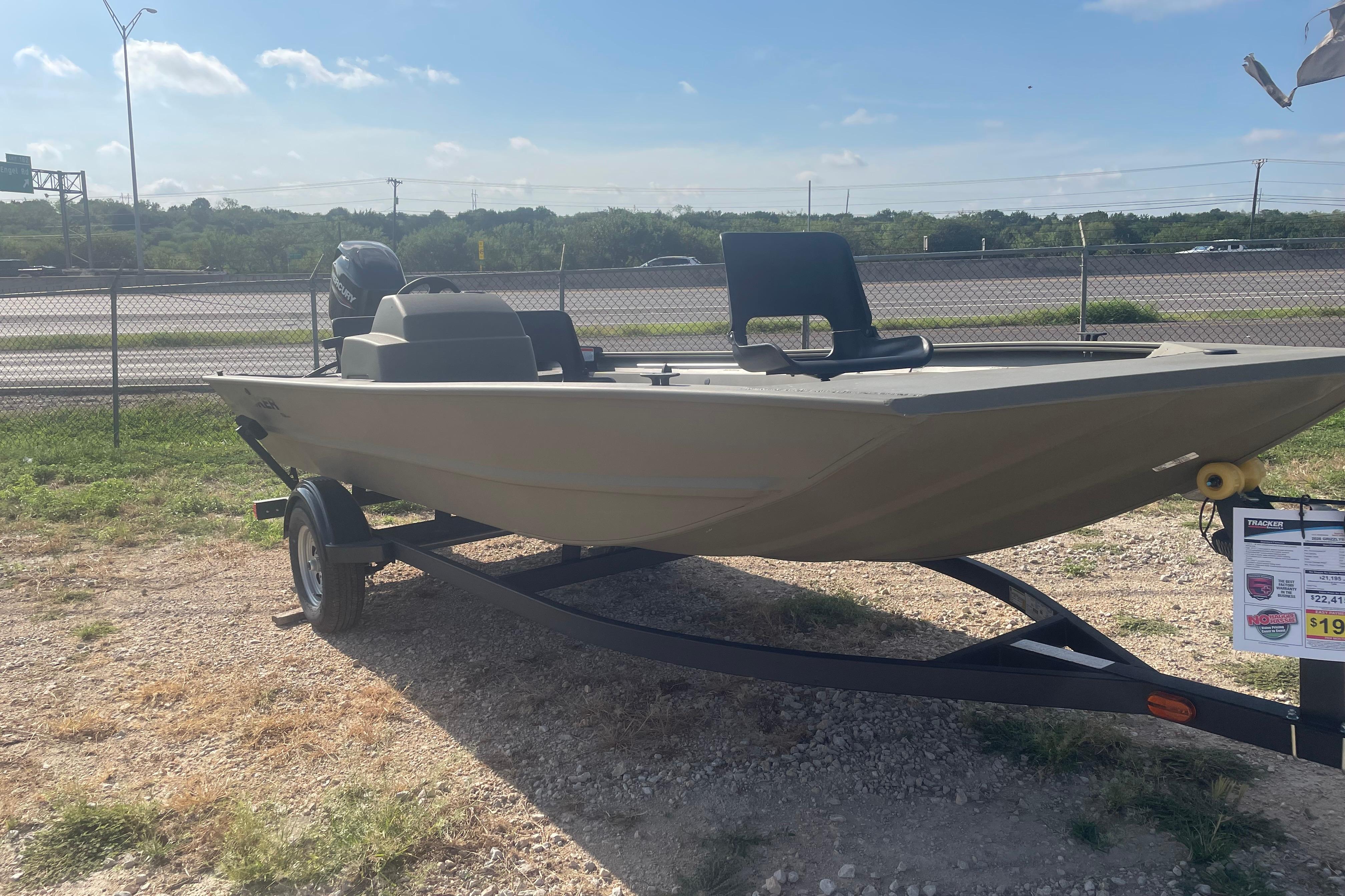 Tracker Grizzly 1754 SC 2026 Tracker Grizzly 1754 SC boat on trailer, parked outdoors under clear sky.