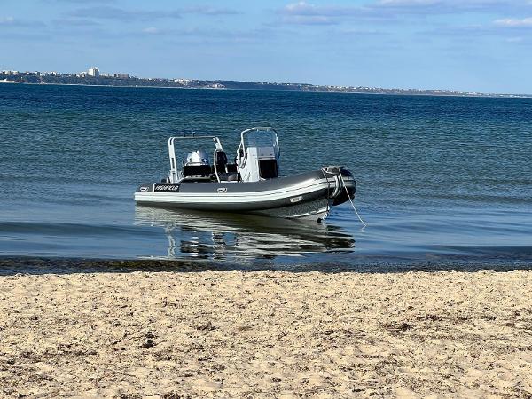 Highfield DL 540 2019 Highfield DL 540 boat anchored near sandy beach with calm blue water.