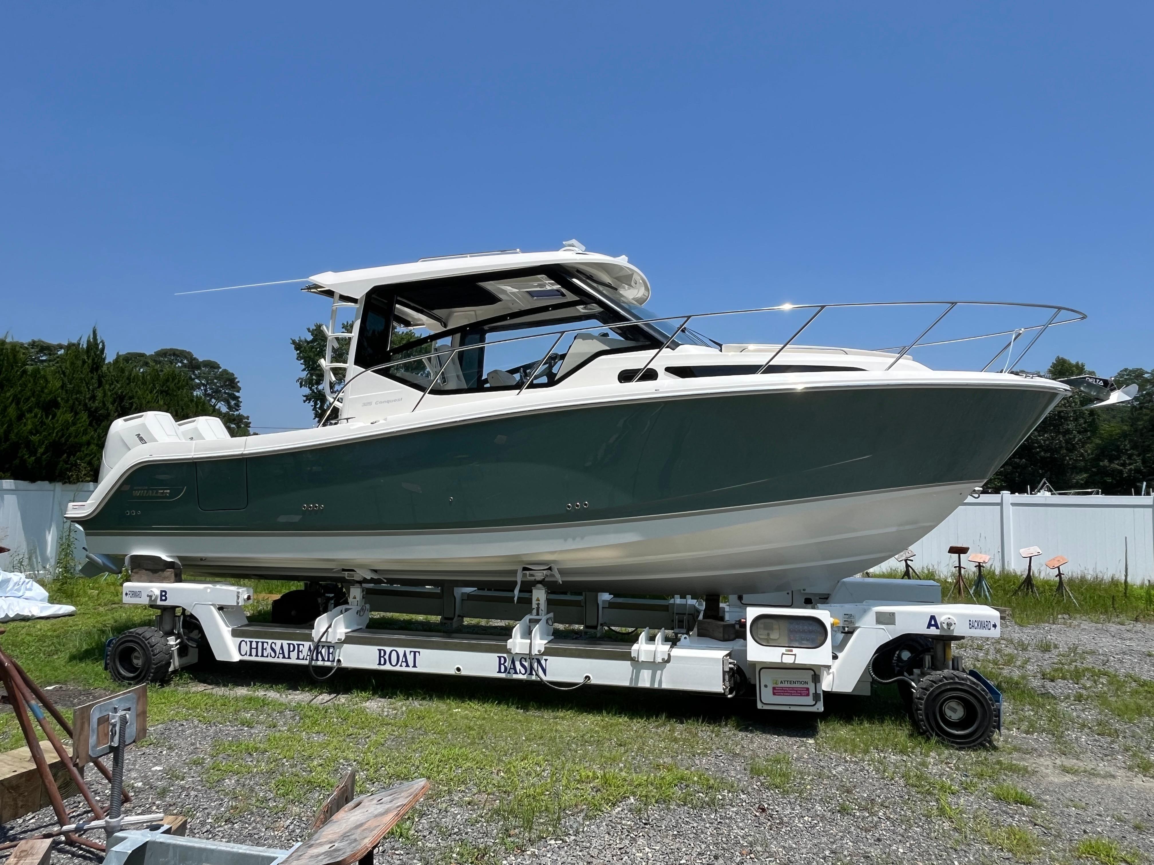 Boston Whaler 325 Conquest 2025 Boston Whaler 325 Conquest boat on trailer under clear blue sky.