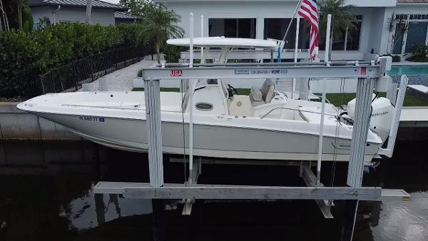 Boston Whaler 270 Dauntless 2020 Boston Whaler 270 Dauntless boat on lift near waterfront home.