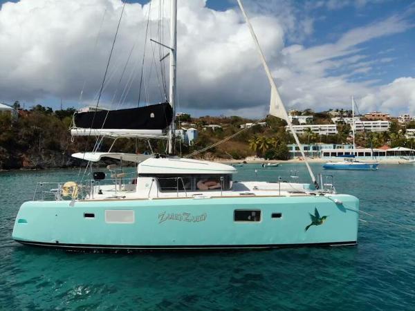 Lagoon 39 2014 Lagoon 39 catamaran sailing in clear turquoise waters near a tropical coastline.