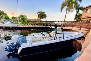 Sailfish 270 CC 2015 Sailfish 270 CC boat docked by a waterfront home, surrounded by palm trees.