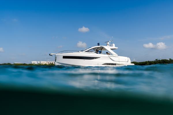 Jeanneau DB 37 2024 Jeanneau DB 37 OB yacht on calm blue water under clear sky.
