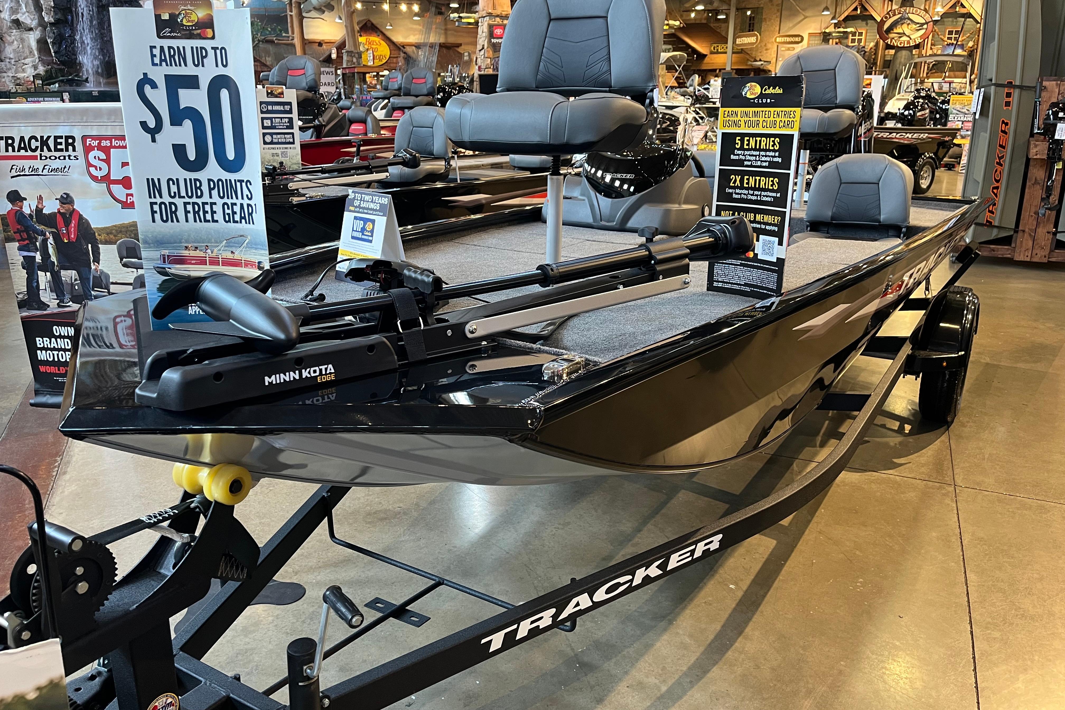 Tracker Pro 170 2025 Tracker Pro 170 boat displayed in a showroom with promotional signs.