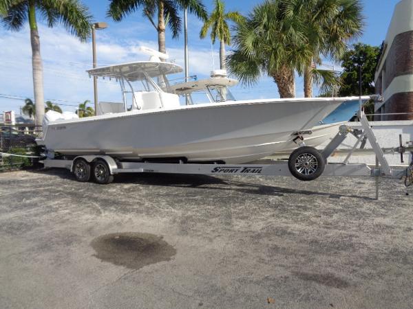 Contender 32 ST 2022 Contender 32 ST boat on trailer, parked outdoors with palm trees in the background.