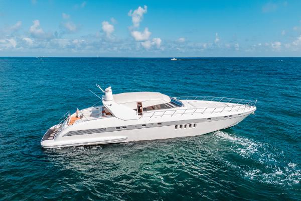 Mangusta 80 Luxury 2001 Mangusta 80 yacht cruising on open sea under clear blue sky.