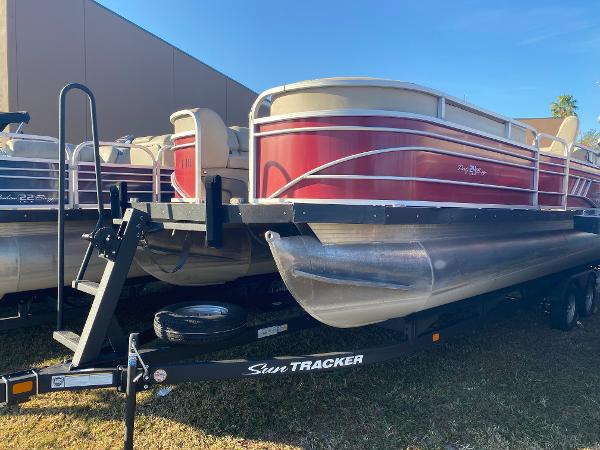Sun Tracker Party Barge 24 DLX 2020 Sun Tracker Party Barge 24 DLX pontoon boat on trailer, red and white design.