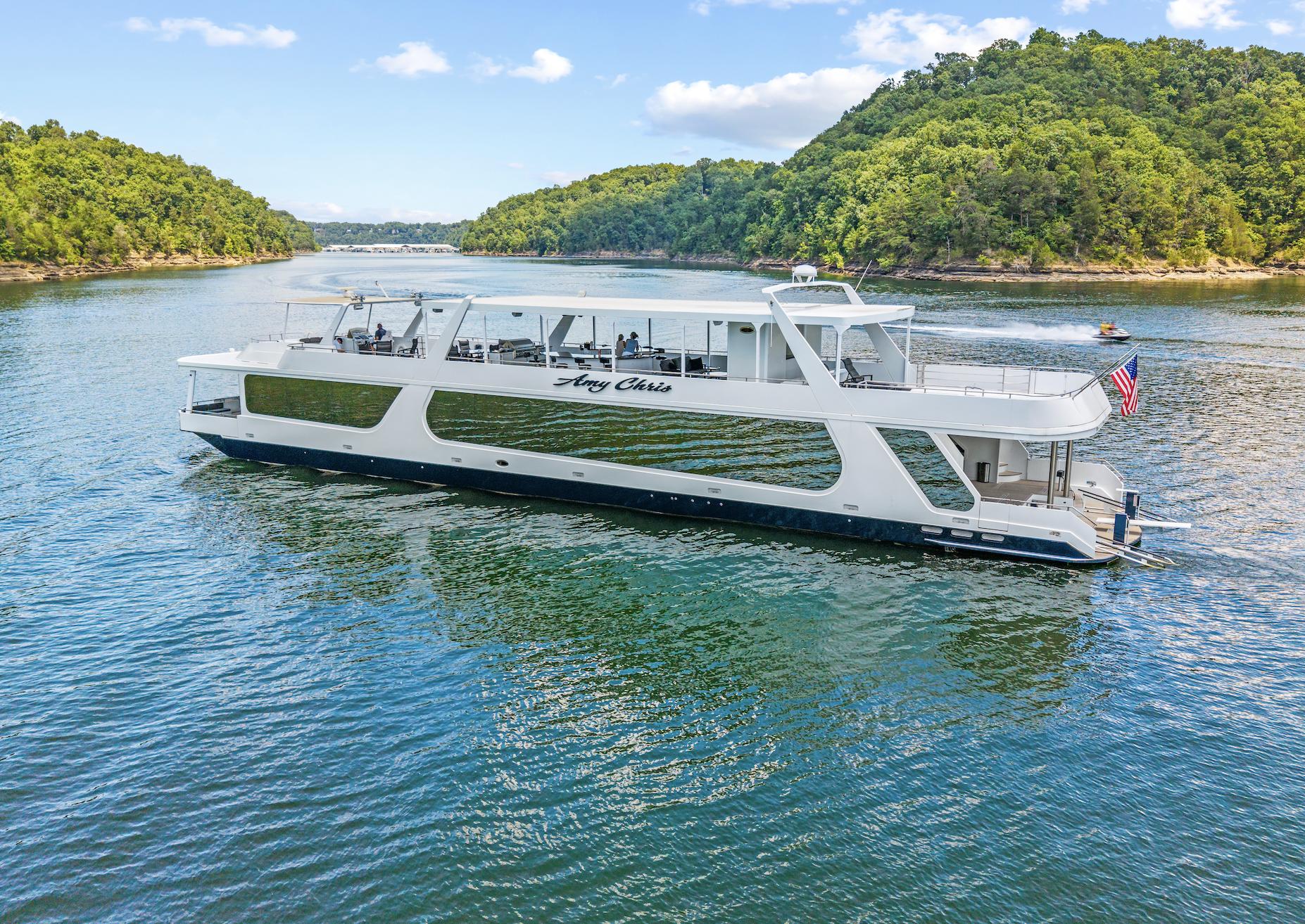 Sumerset 23' x 118' 2009 Sumerset 23' x 118' houseboat cruising on a scenic lake with lush green hills.