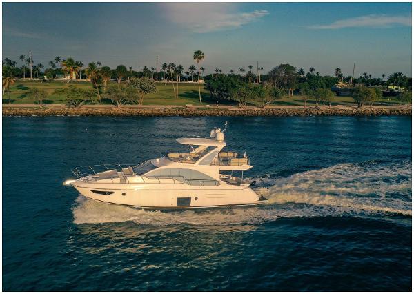 Azimut Fly 50 Azimut 2022 Fly yacht cruising on a scenic waterway near lush greenery.