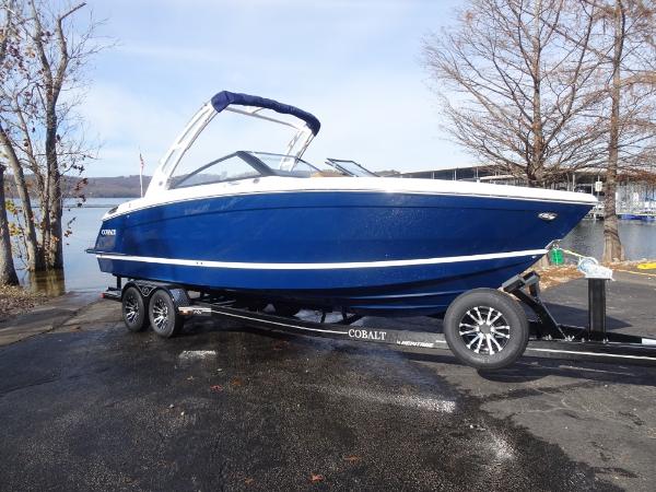 Cobalt R8 2025 Cobalt R8 boat on trailer by lakeside, blue hull, sleek design.