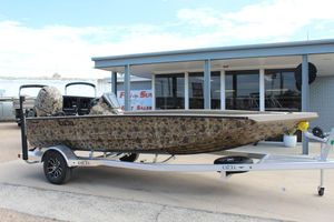 Excel Bolt 183 2026 Excel Bolt 183 boat with camouflage design on a trailer outside a dealership.