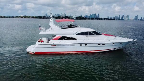 Fairline Squadron 65 1999 Fairline Squadron 65 yacht cruising on calm waters with city skyline in the background.