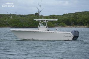 Sailfish 242 CC 2024 Sailfish 242 CC boat on water, side view, with lush green background.