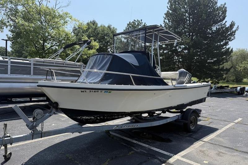 Parker 18 CC 1996 Parker 18 CC boat on trailer, parked outdoors with trees in the background.