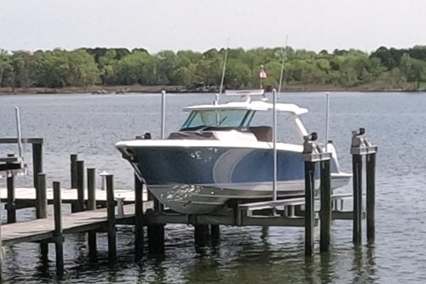 Tiara Yachts 43 LS 2024 Tiara Yachts 43 LS docked on a serene lake with lush green background.