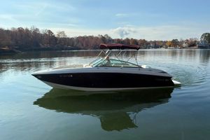 Cobalt 252 2008 Cobalt 252 boat cruising on a calm lake with autumn trees in the background.