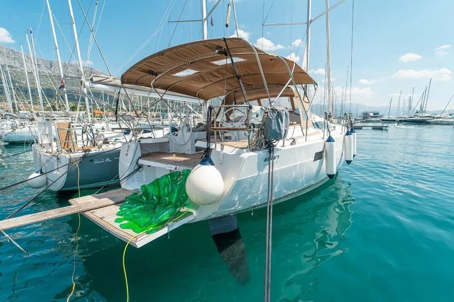 Elan Impression 50 2019 Elan Impression 50 yacht docked in a marina, surrounded by clear blue water.