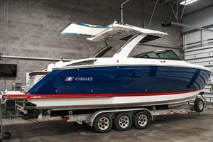 Cobalt R33 2025 Cobalt R33 boat in a garage, blue and white design, on a trailer.