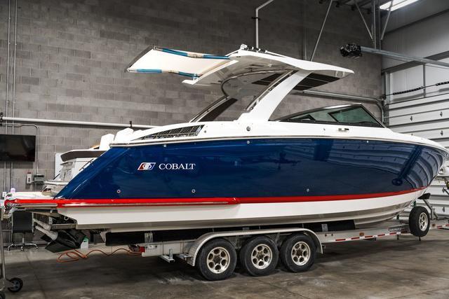 Cobalt R33 2025 Cobalt R33 boat in a garage, blue and white design, on a trailer.