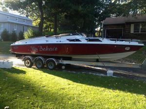 Magnum 27 Sport Sedan 1970 Magnum 27 Sport Sedan boat on trailer, red and white, parked in residential area.
